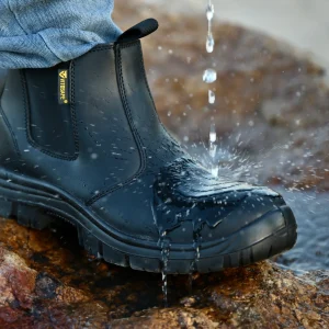 Vitosafe black waterproof safety boot repelling water on a wet outdoor worksite surface